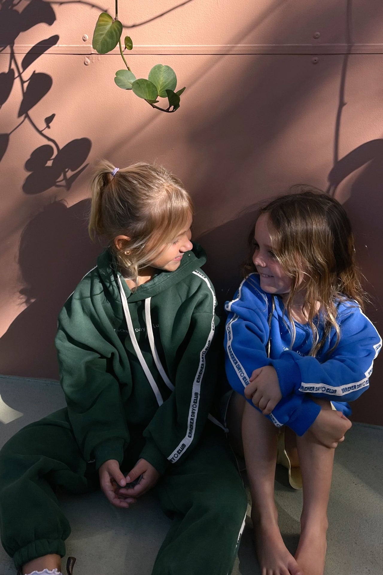 child wearing kids cloud racer sweater by cracker day club and talking to friend