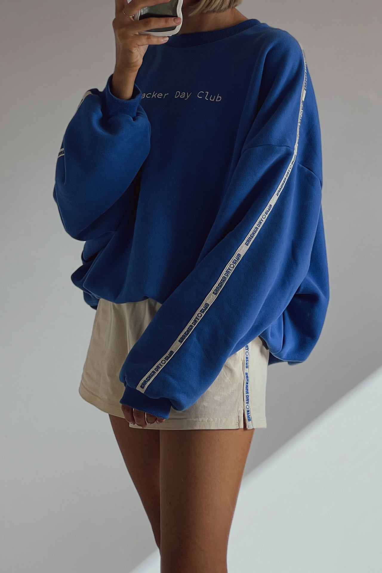 cloud racer sweater in blue with cracker day club embroidery on the sleeve