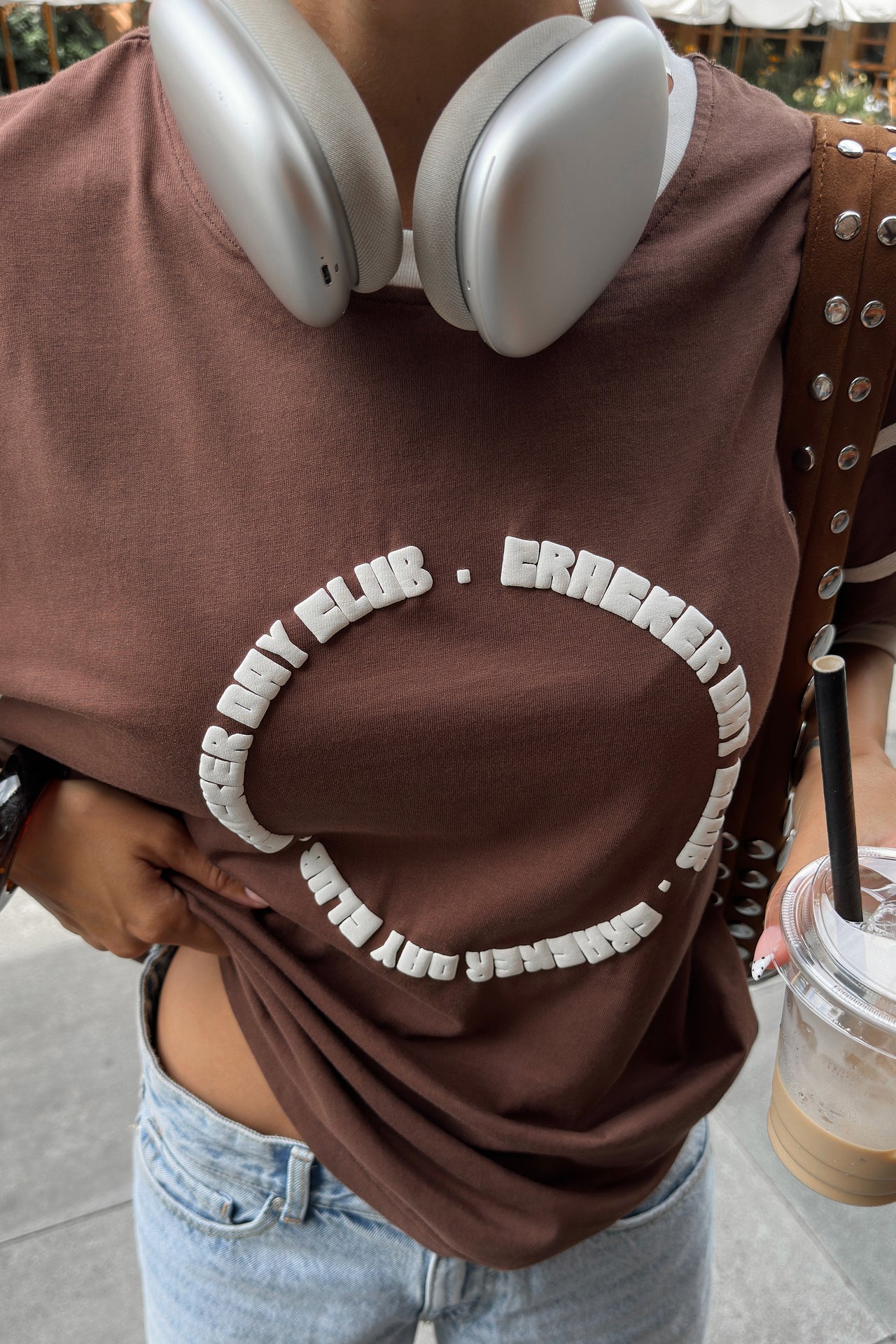 girl drinking coffee in a cracker day club chocolate racer tee