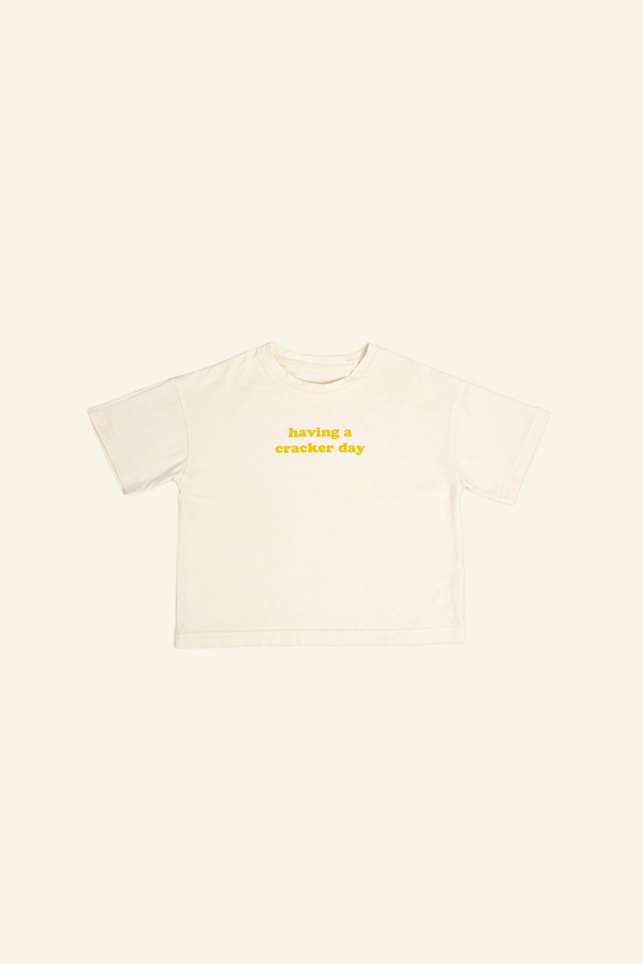 cracker day club tshirt in butter with slogan having a cracker day in mustard
