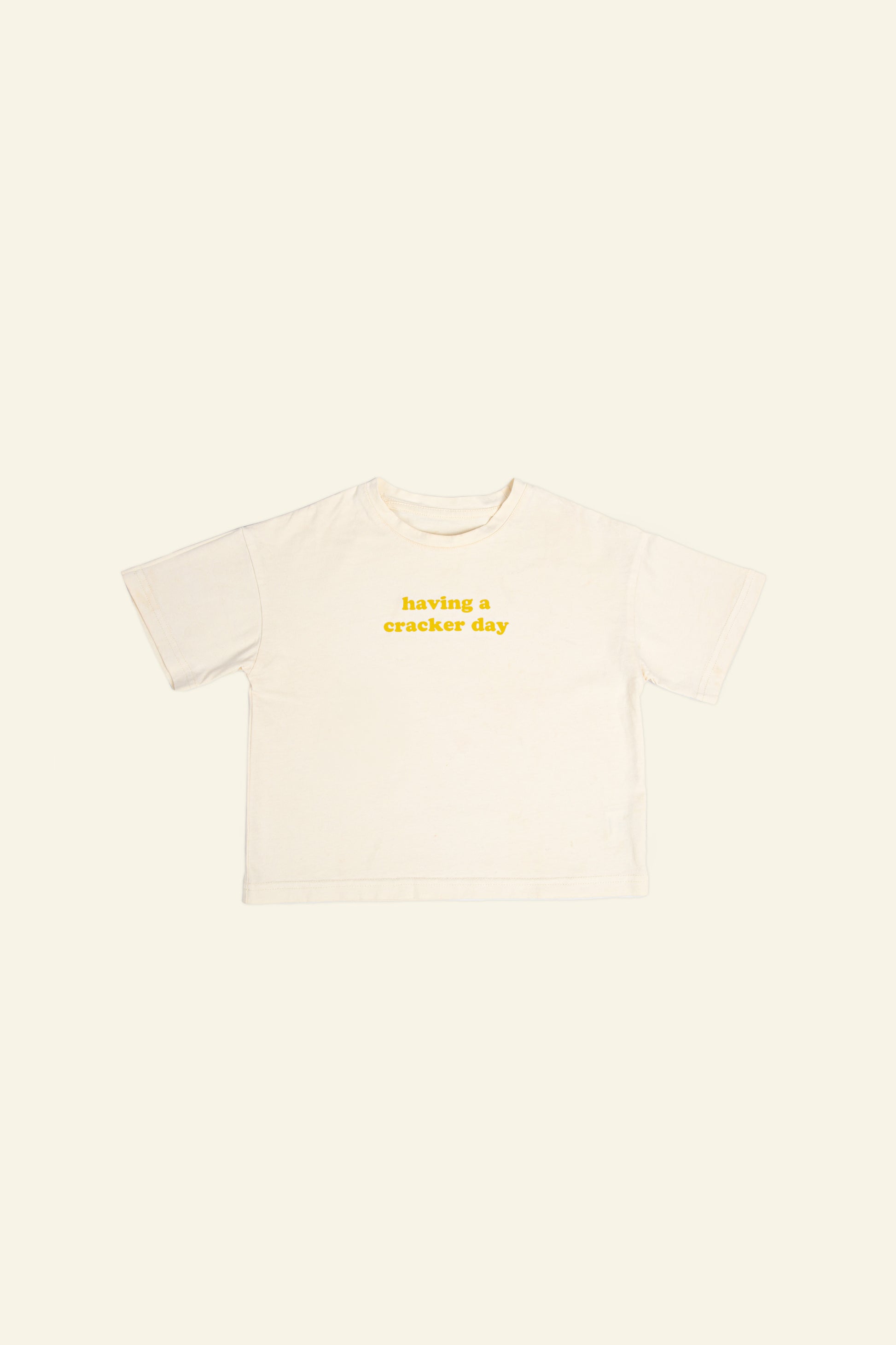 cracker day club tshirt in butter with slogan having a cracker day in mustard