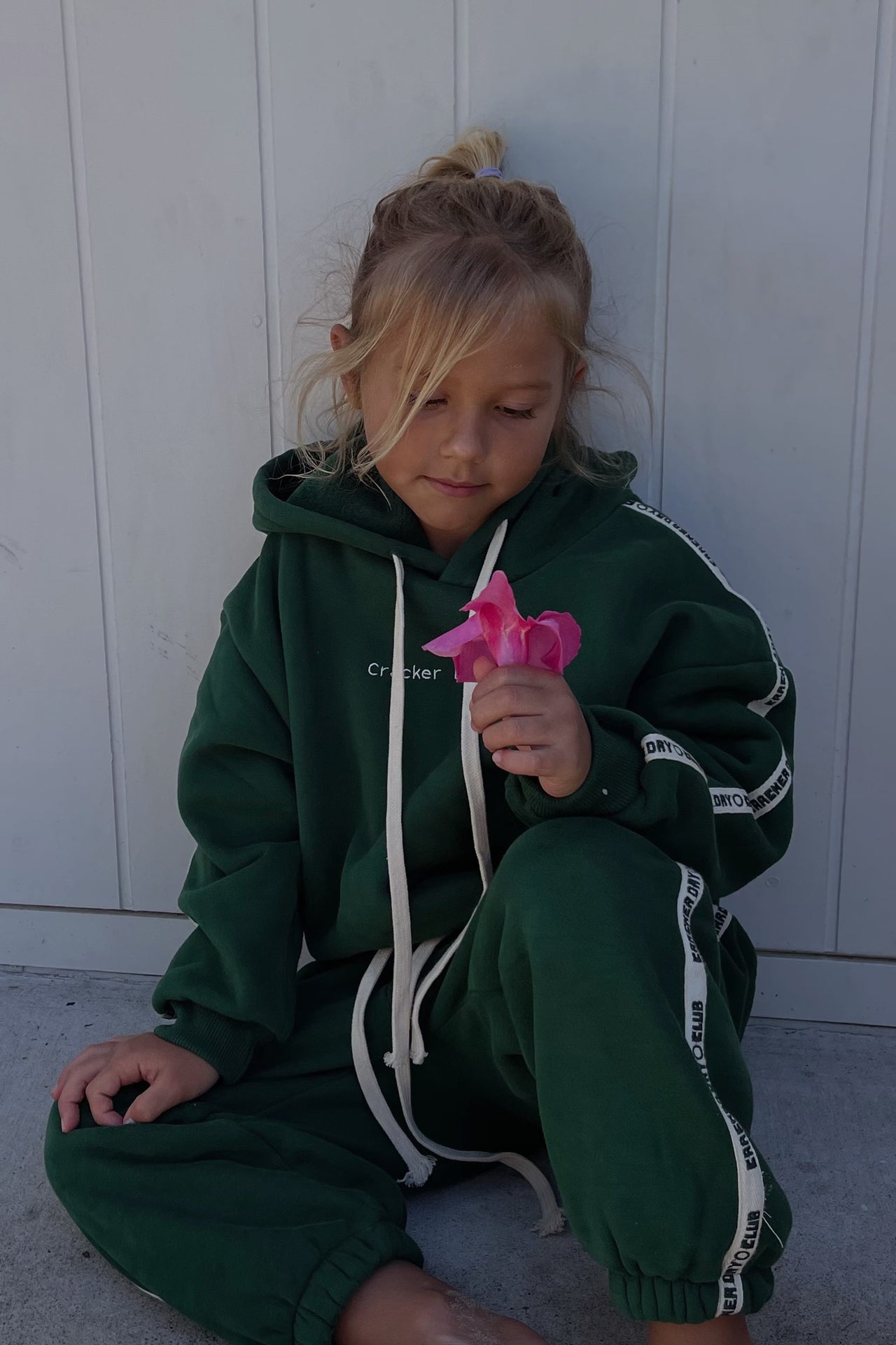 child wearing kids cloud racer sweater by cracker day club and talking to friend