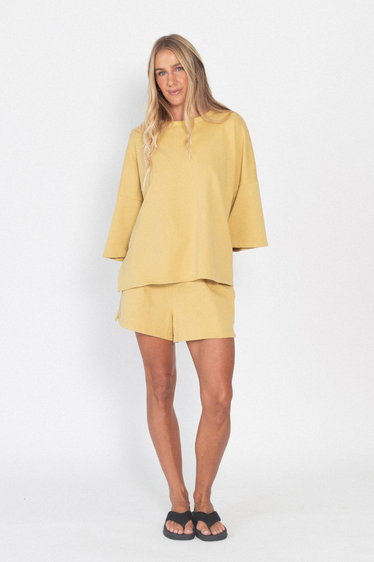 Woman wearing a yellow outfit on a white background