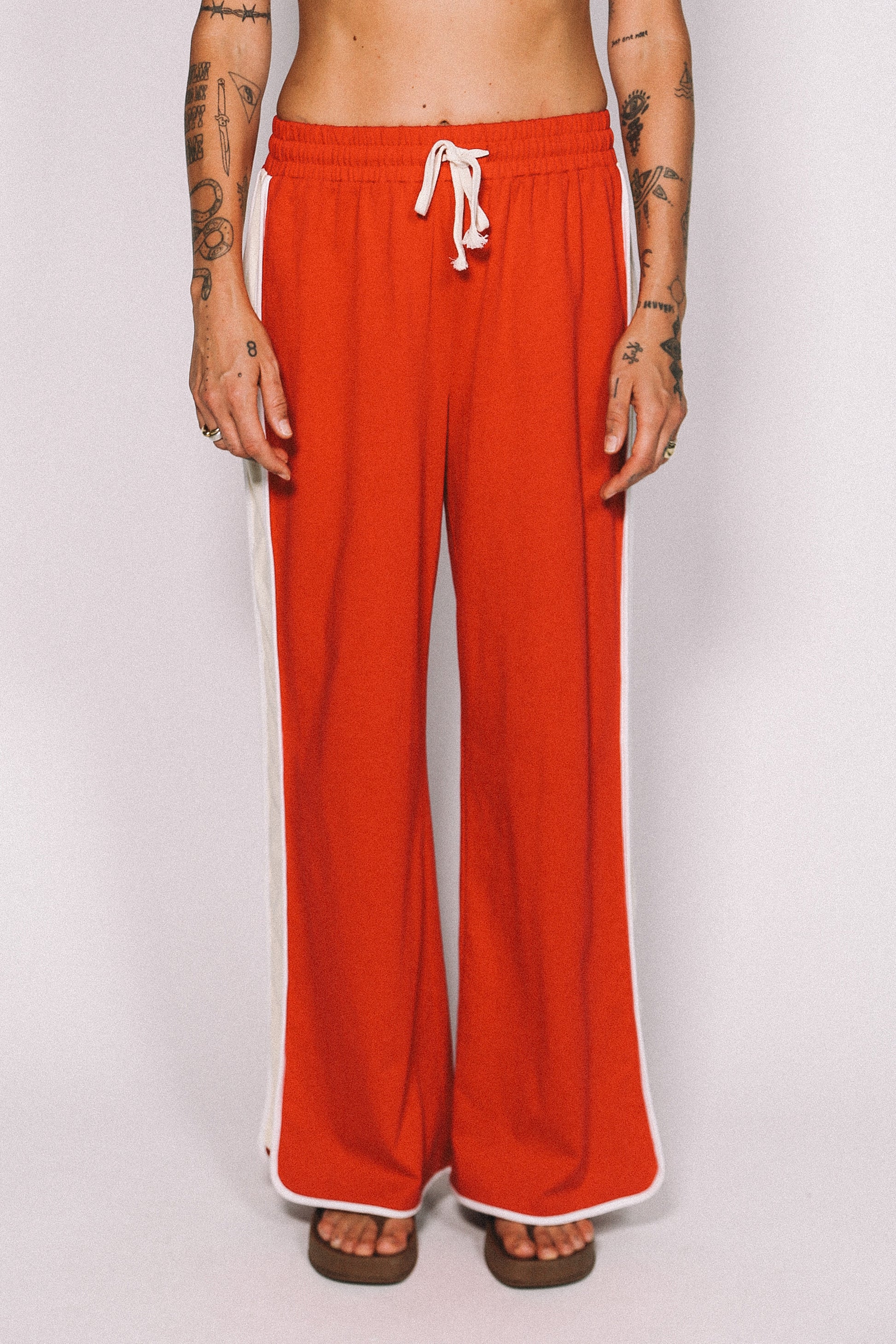 Red pants with a white drawstring on a plain background