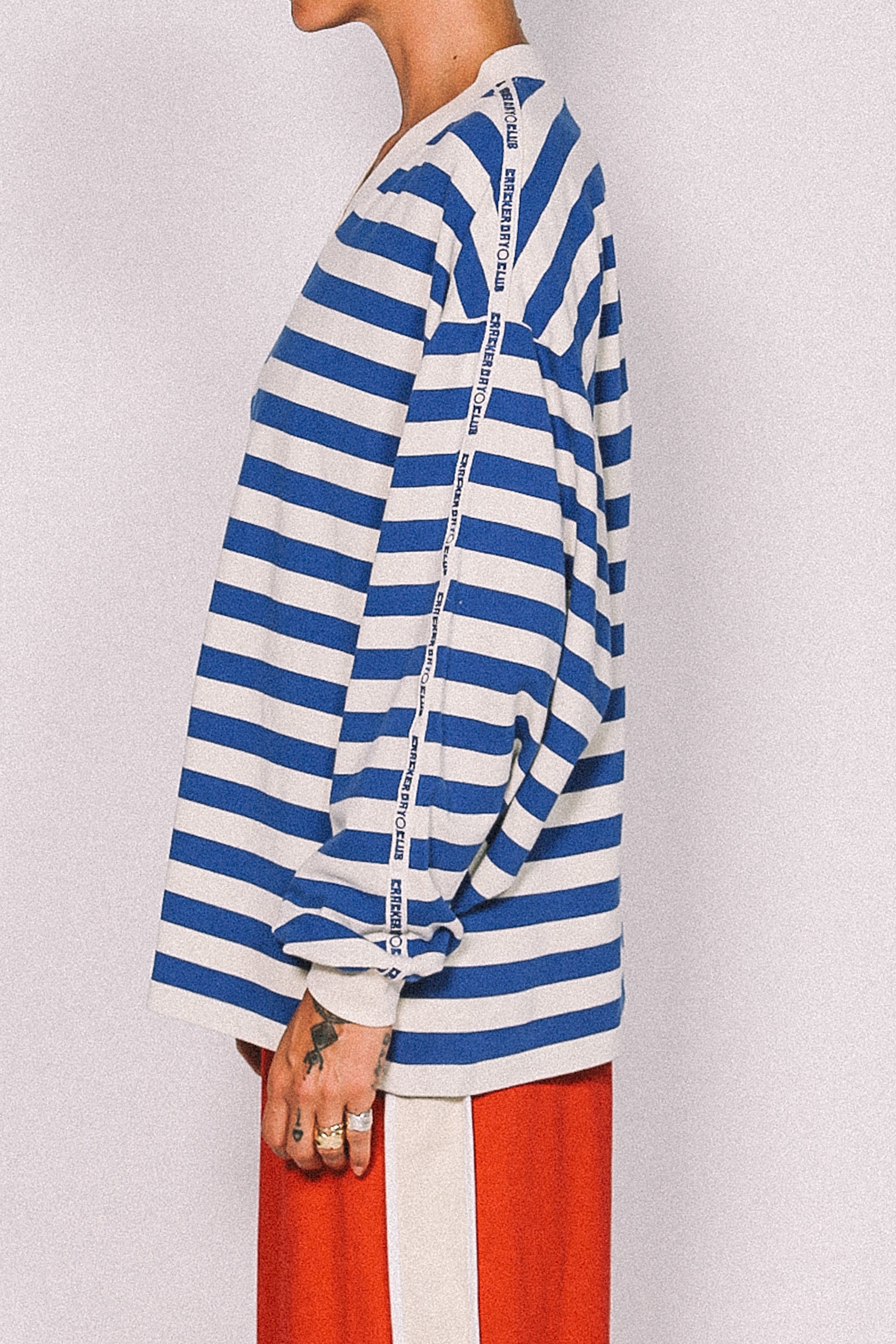 Person wearing a blue and white striped shirt with a plain background