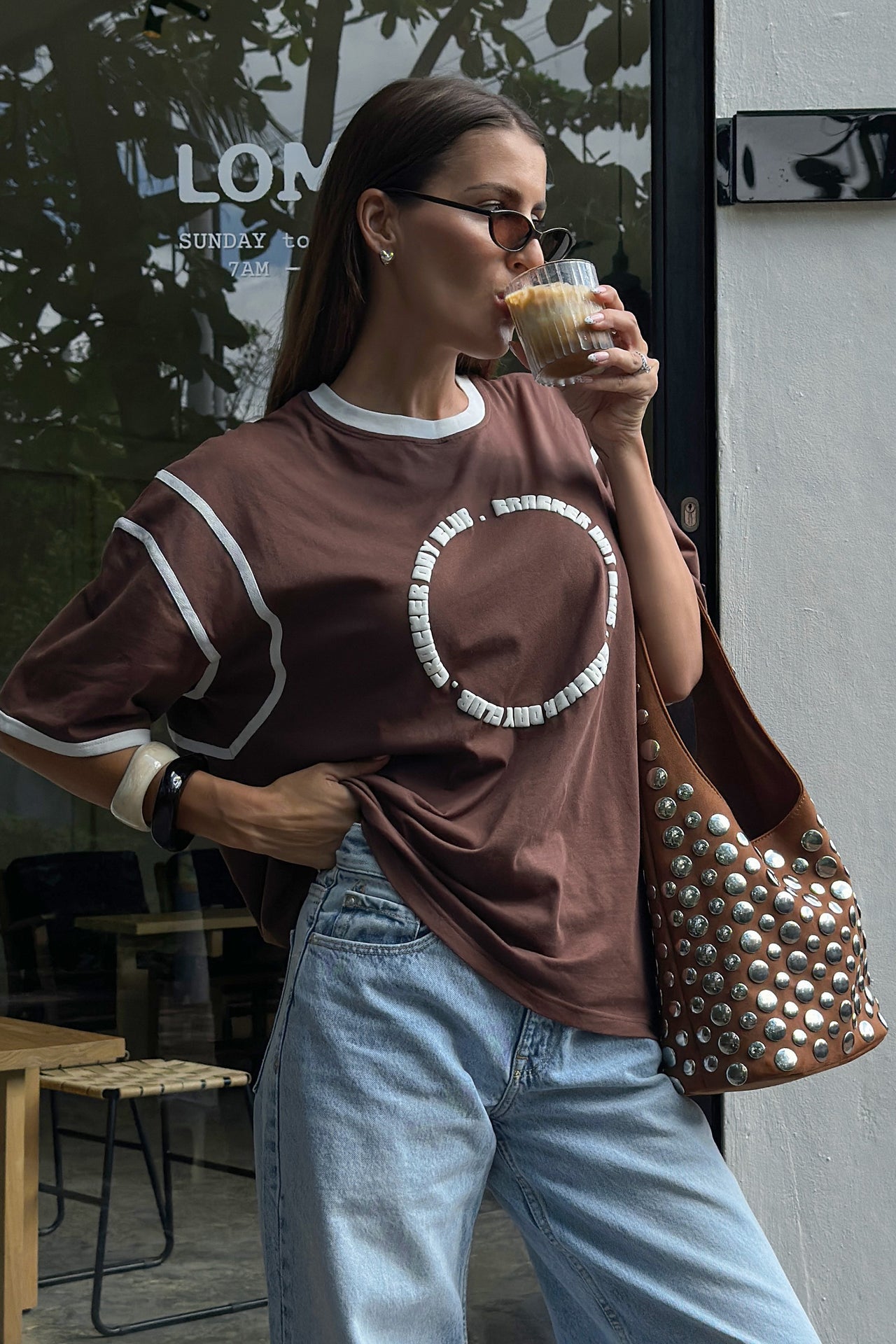 girl drinking coffee in a cracker day club chocolate racer tee